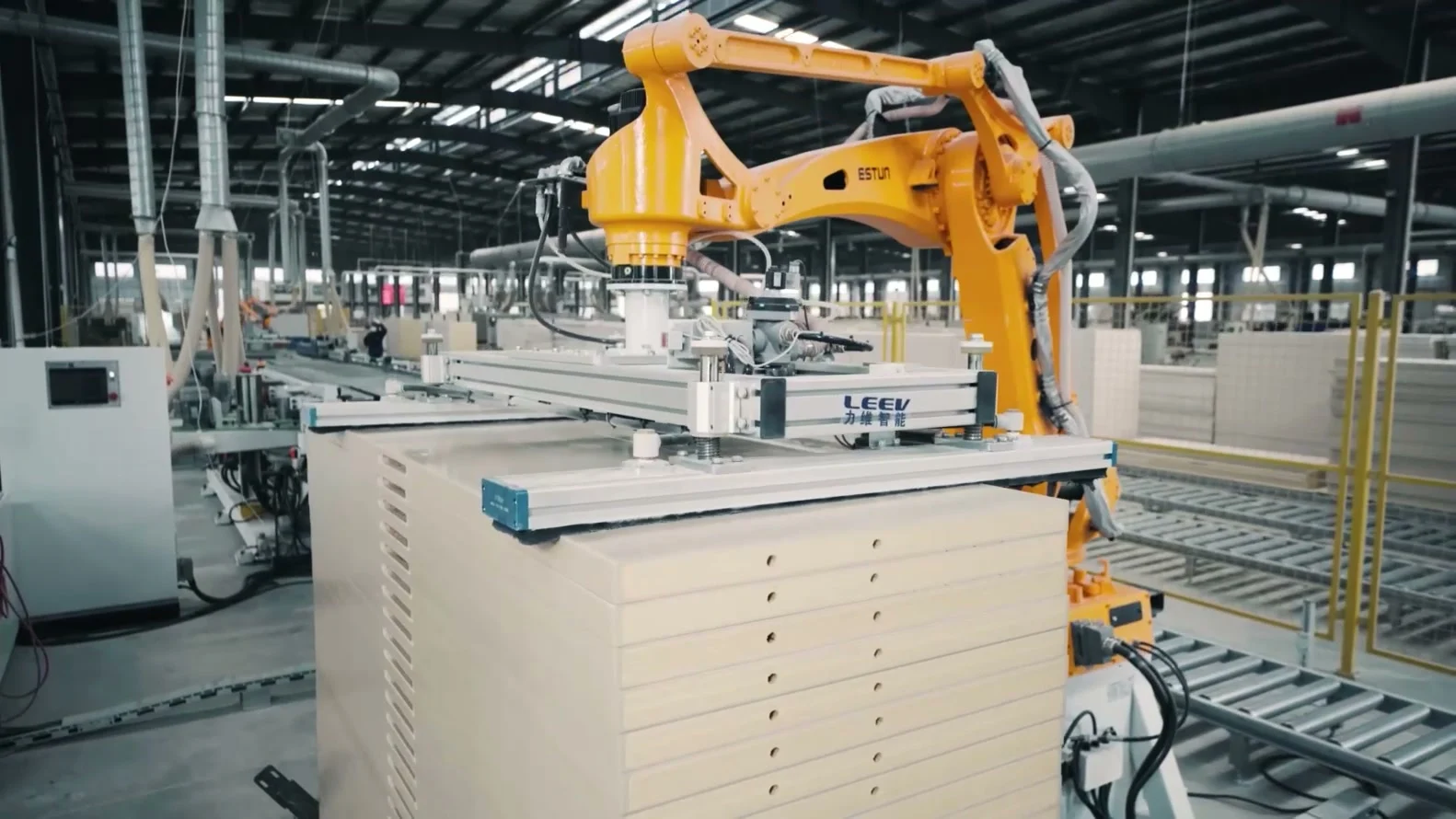ESTUN robot handling a panel above a stack at the end of a line.